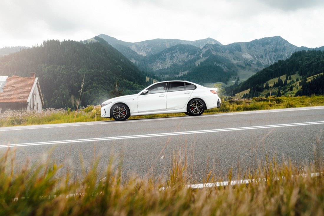 Weißer BMW auf einer Bergstraße